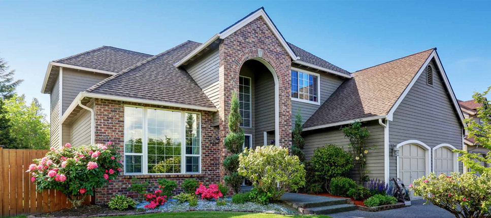 a two-story residential house featuring a combination of brick masonry and dark-colored siding trim
